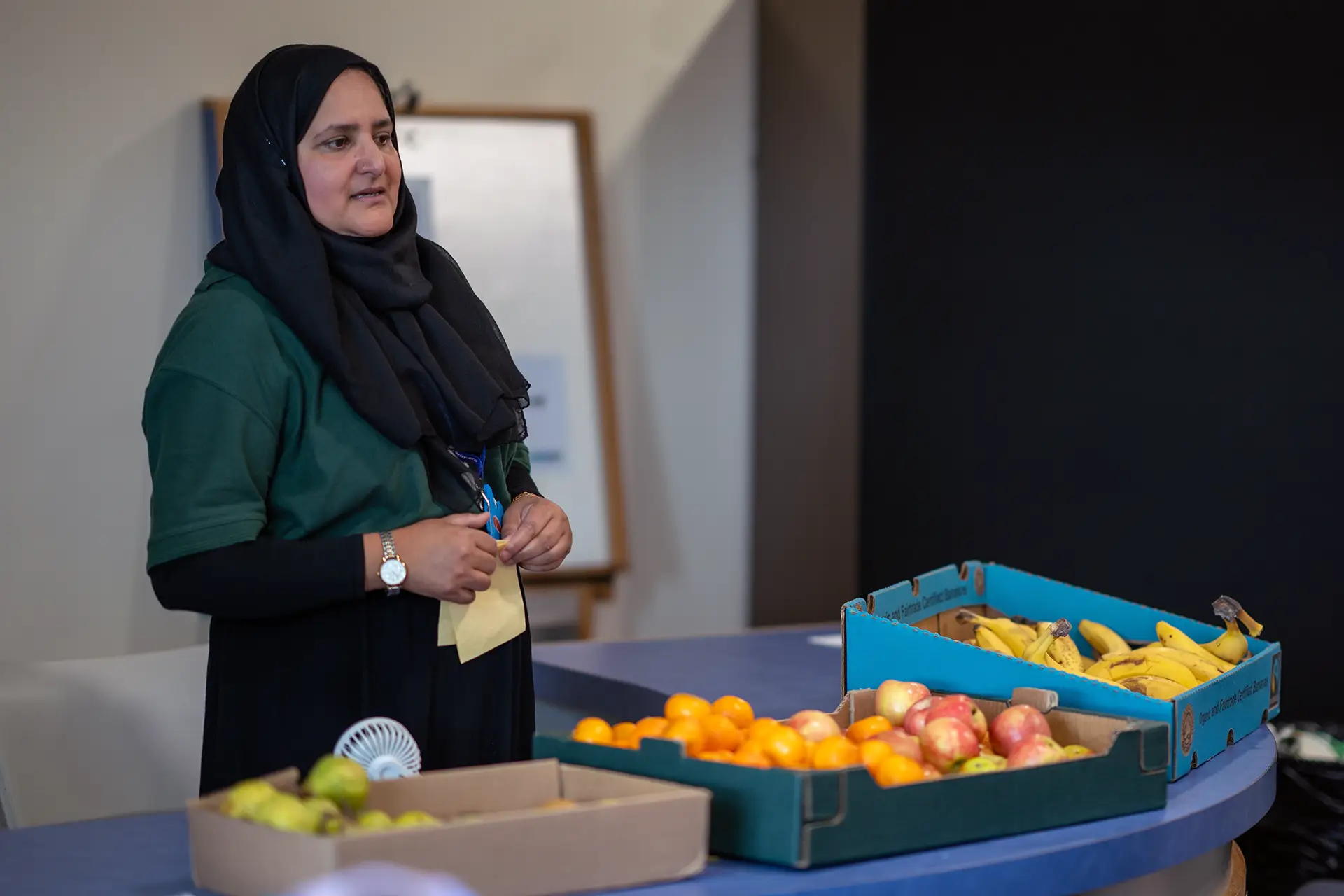 Volunteer handing out fresh fruit to children