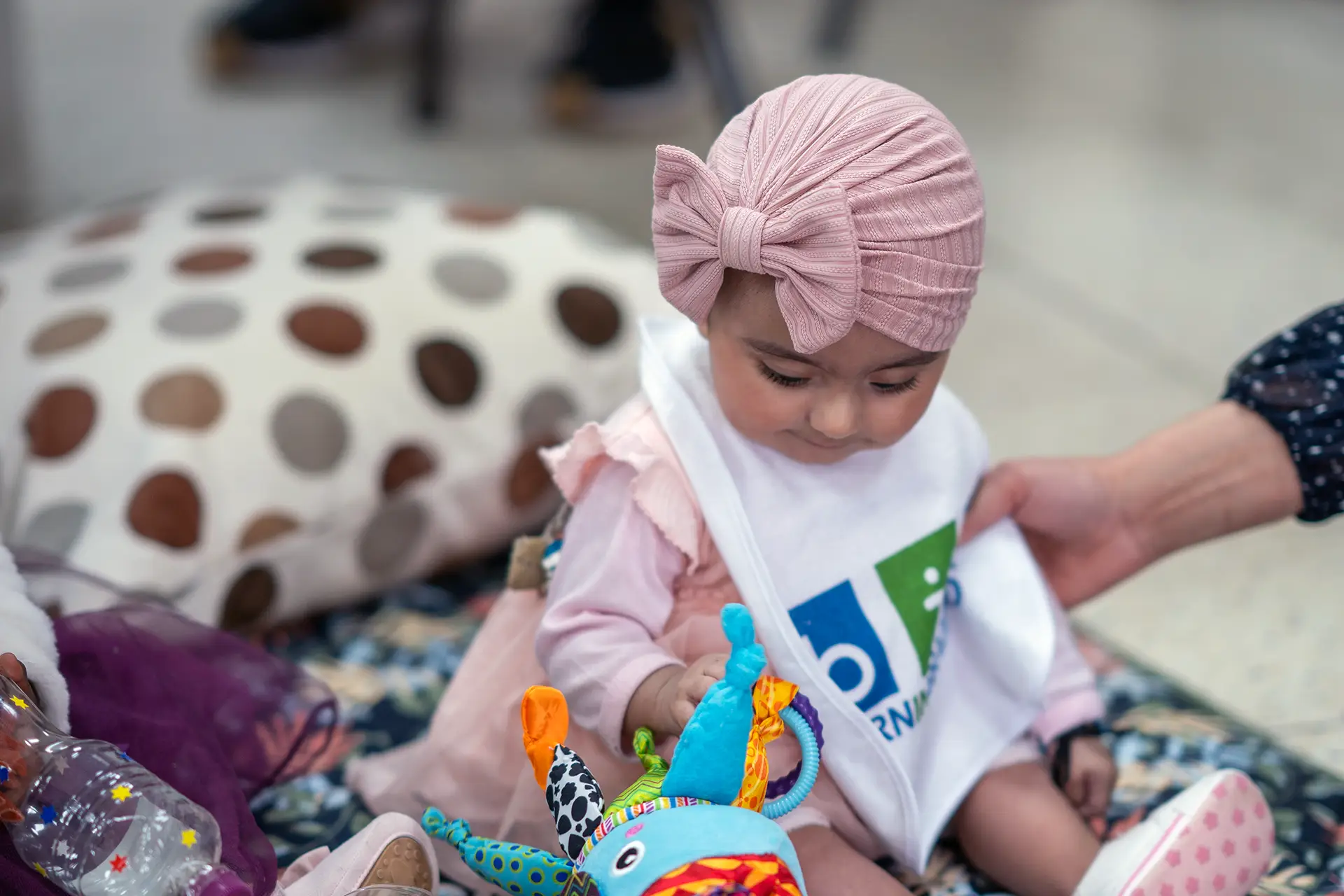 Child sat in soft play area with sensory toy