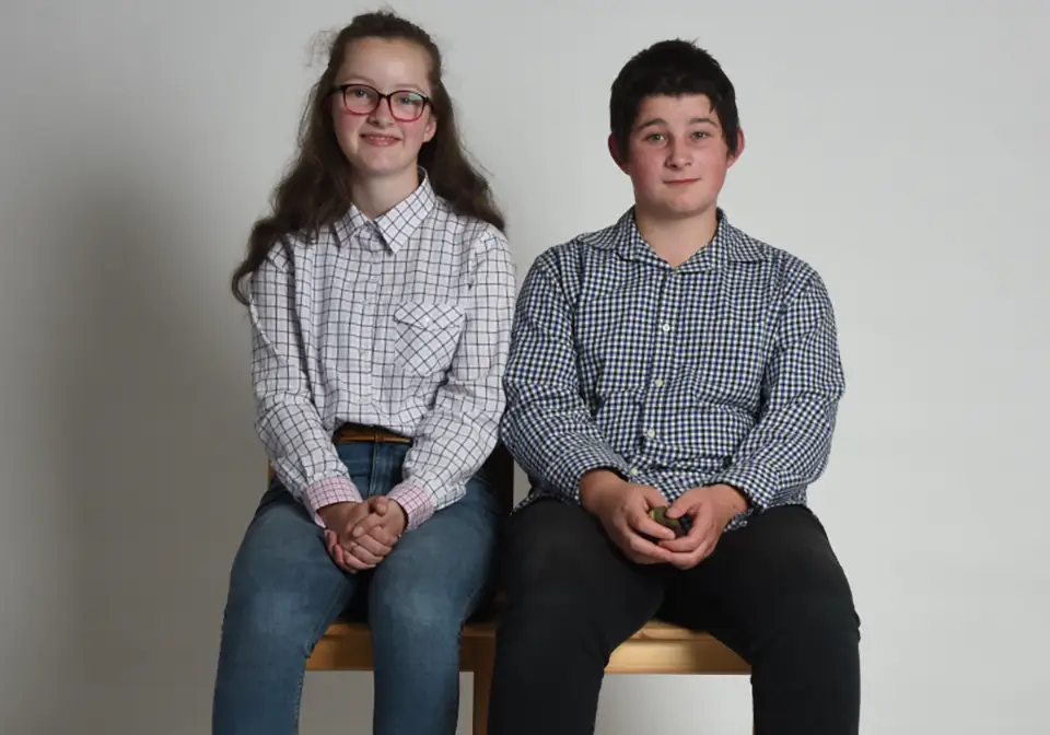 Two teenage twins smiling at the camera