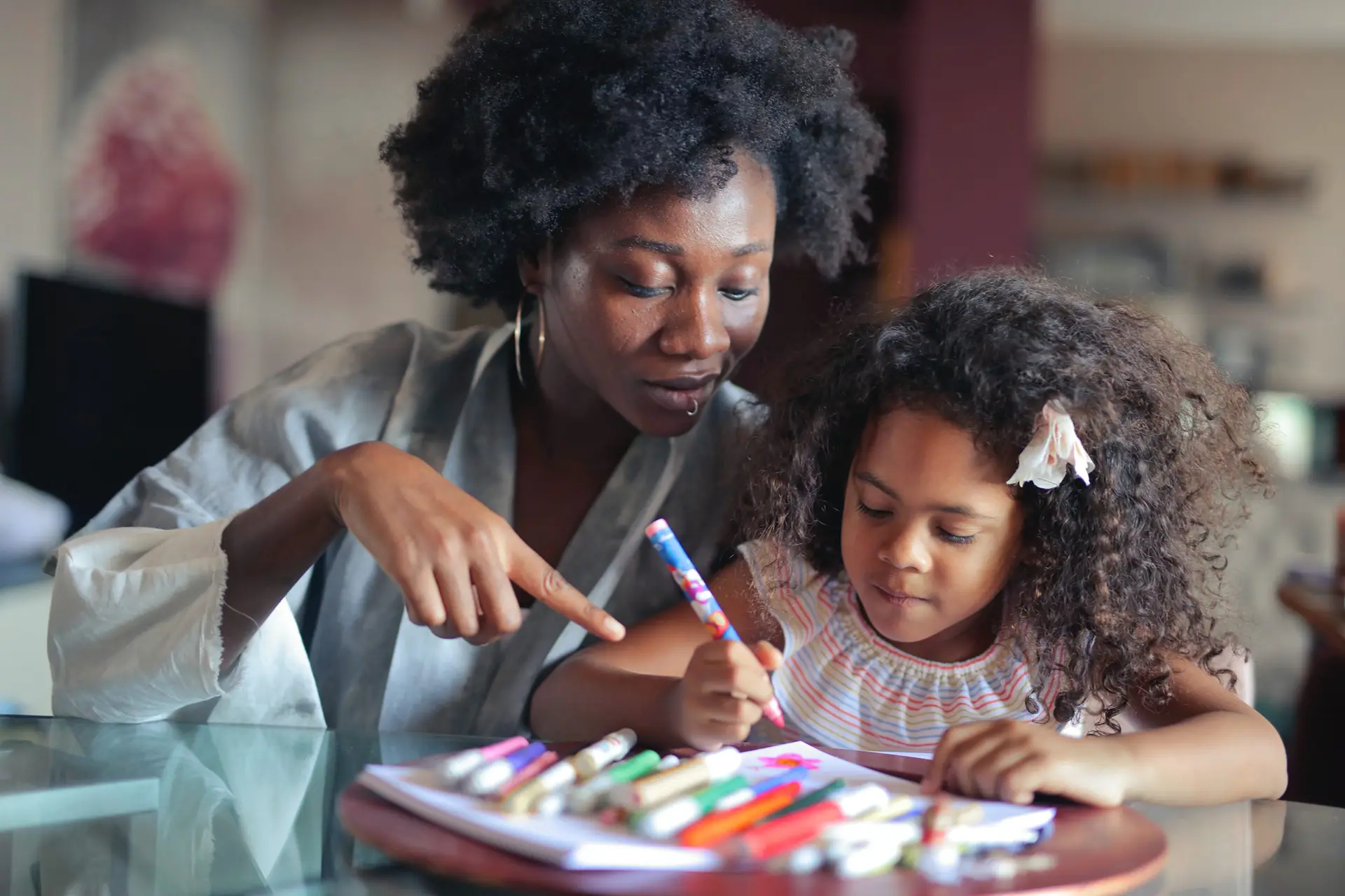 Parent looking over child who is drawing