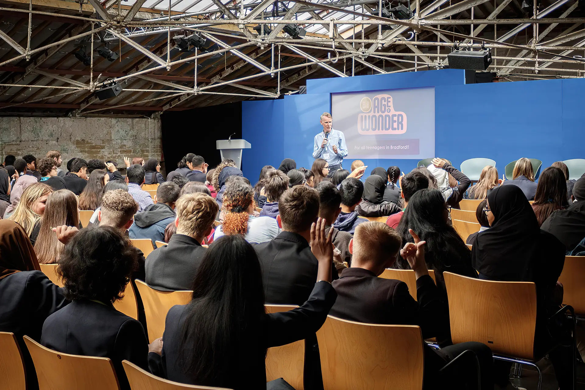 Speaker at conference, with children as audience members