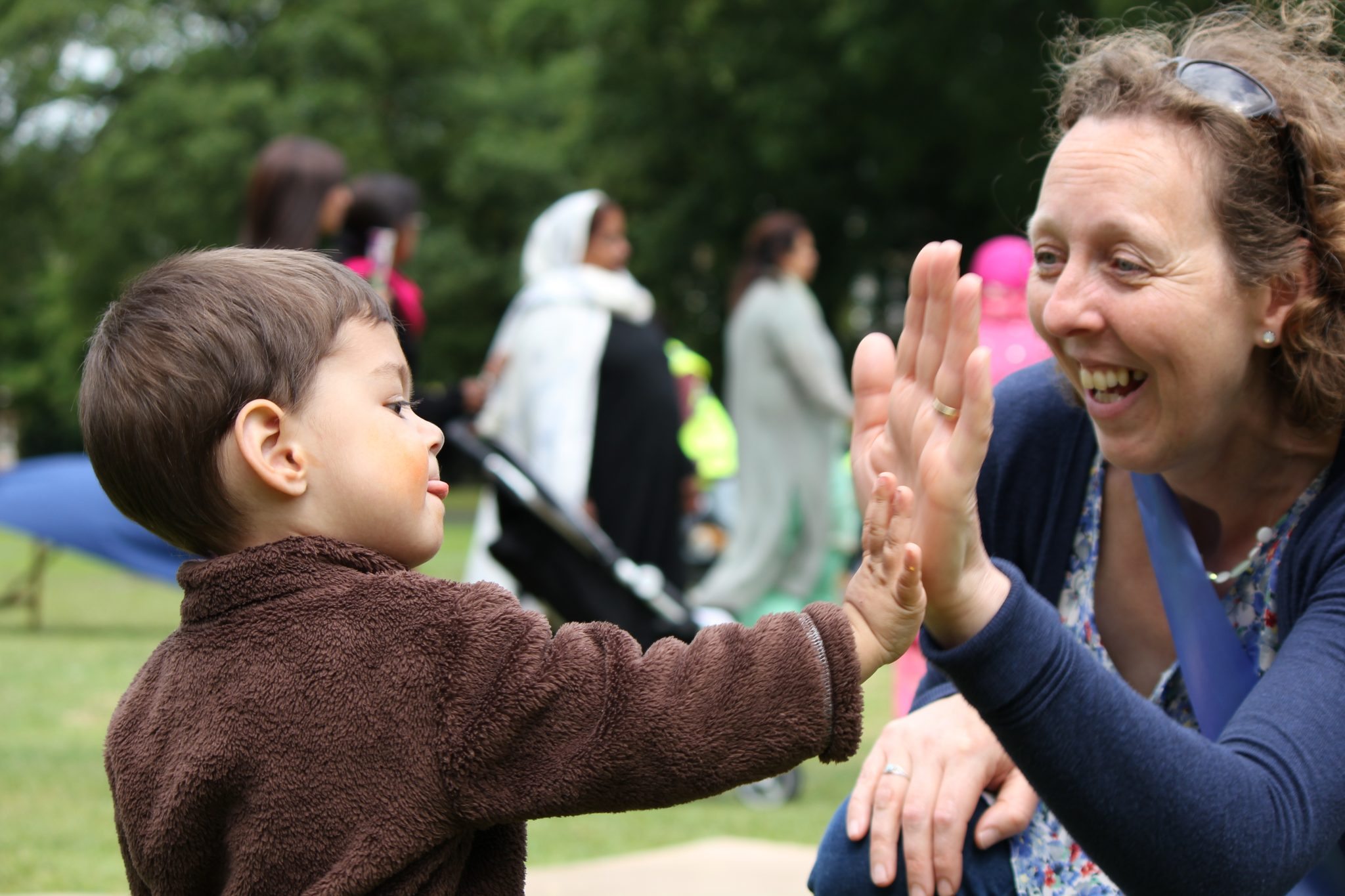 Child high-fiving a Born in Bradford volunteer