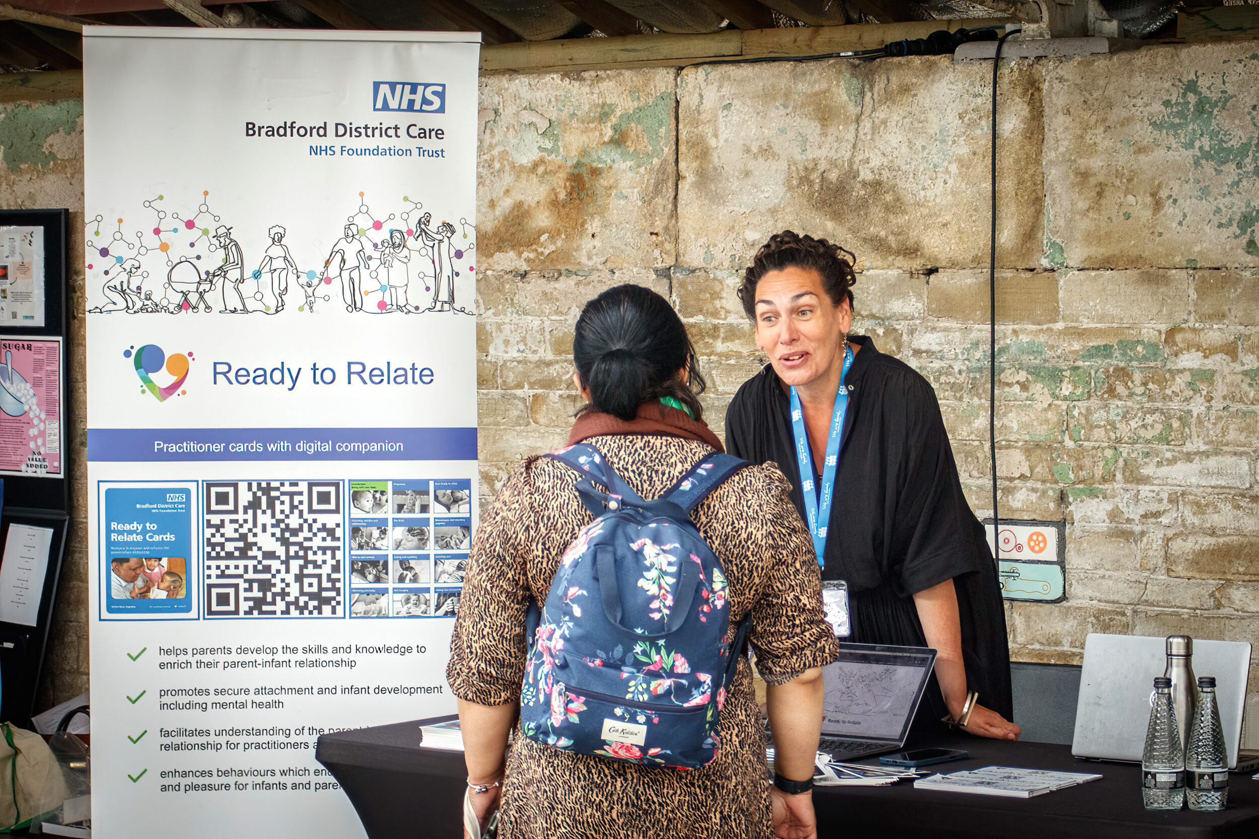 Volunteer from Bradford District Care talking to member of public at a fair