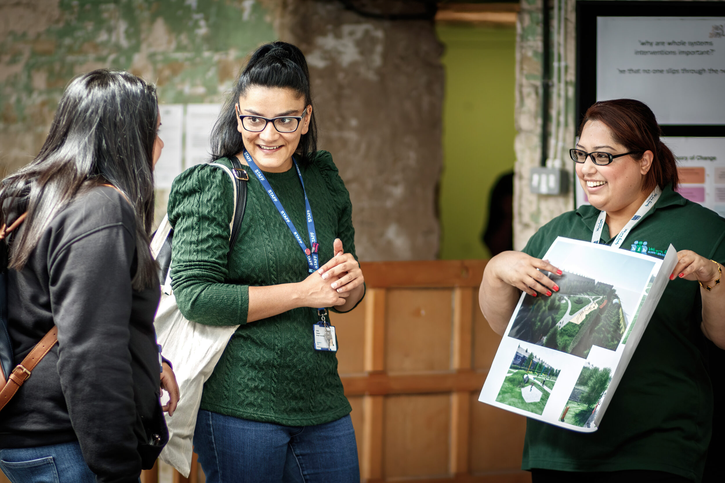 Two employees engaging with a member of the public