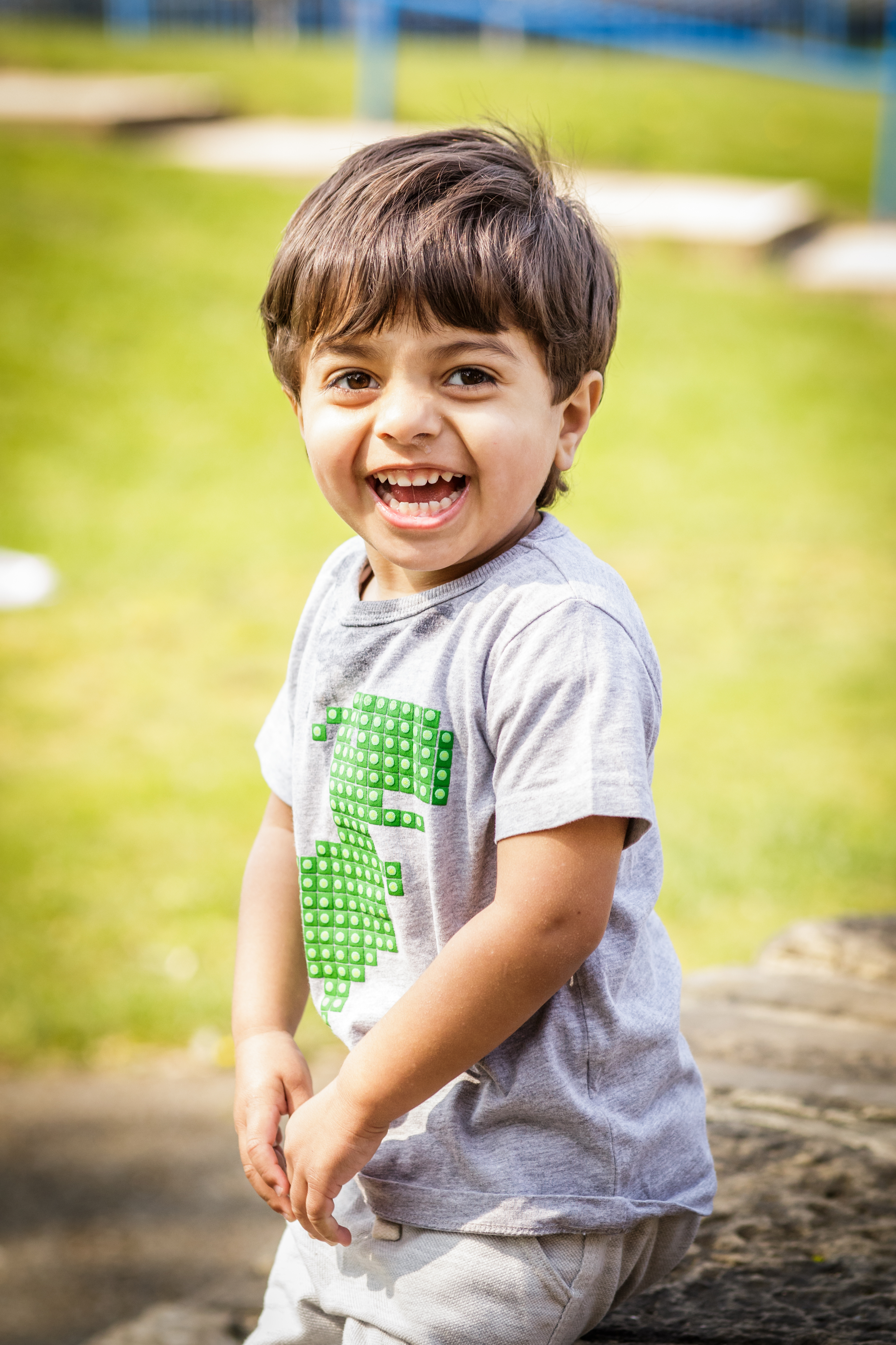 Child in grass stood smiling at camera