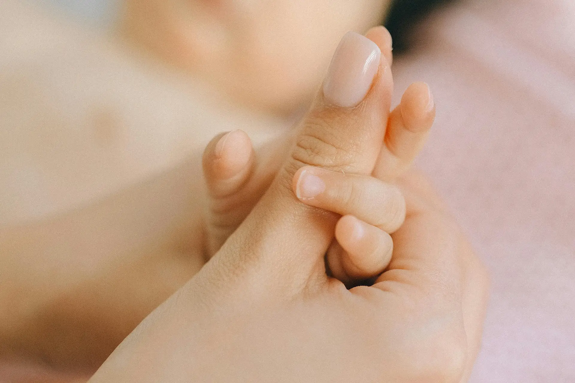 Hand of baby within the hand of a lady