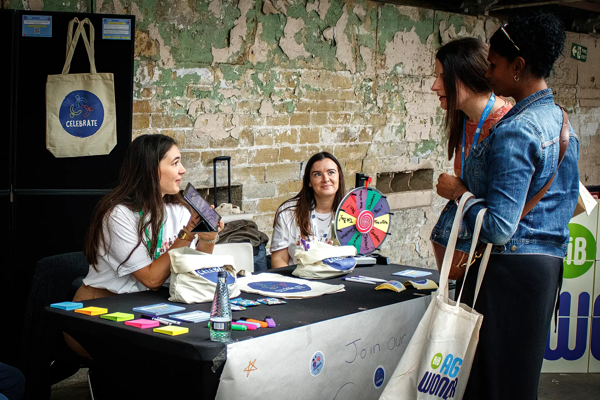 Two volunteers sat at table with two interested members of the public