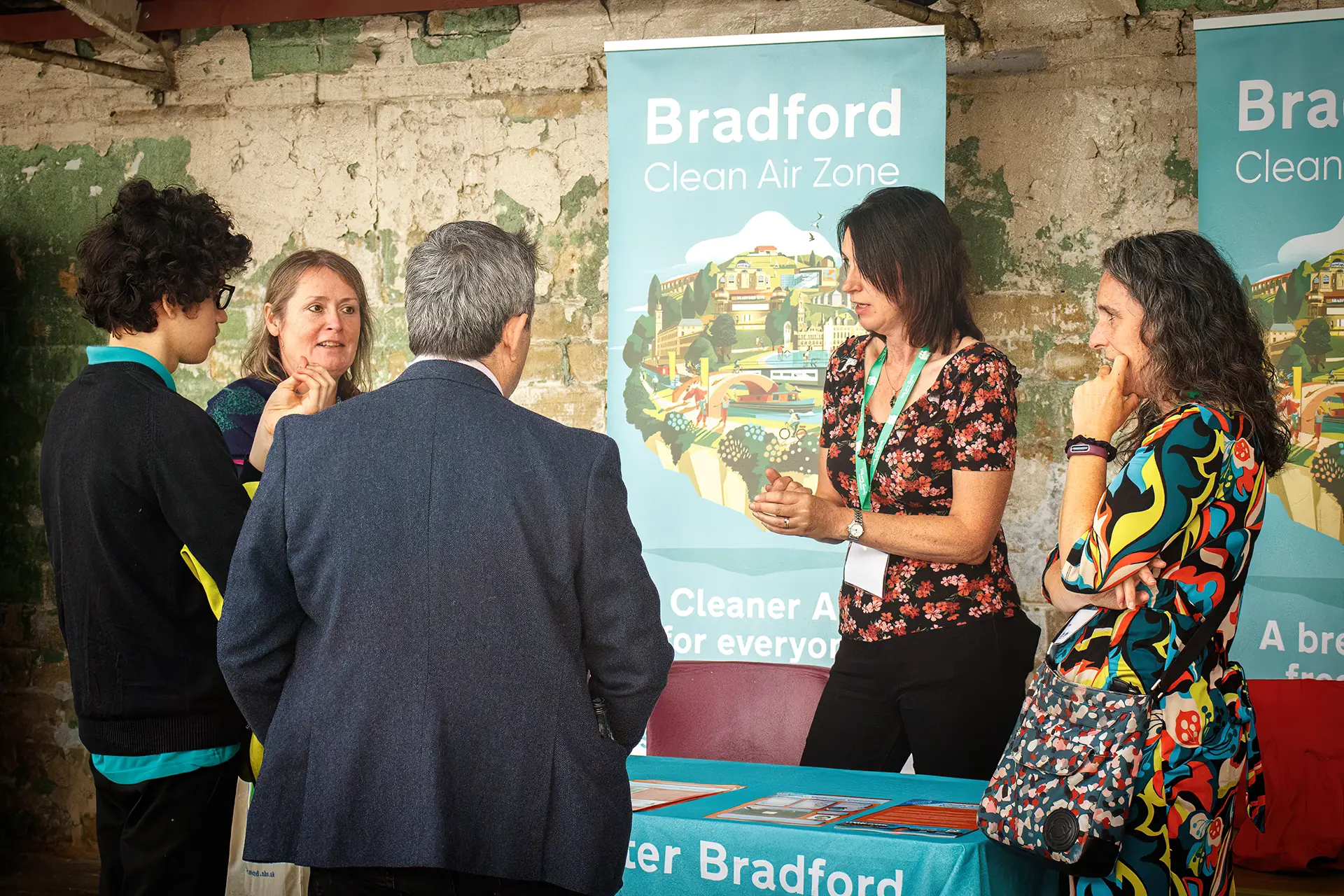 Two volunteers discussing the Clean Air Zone with 3 interest members of the public