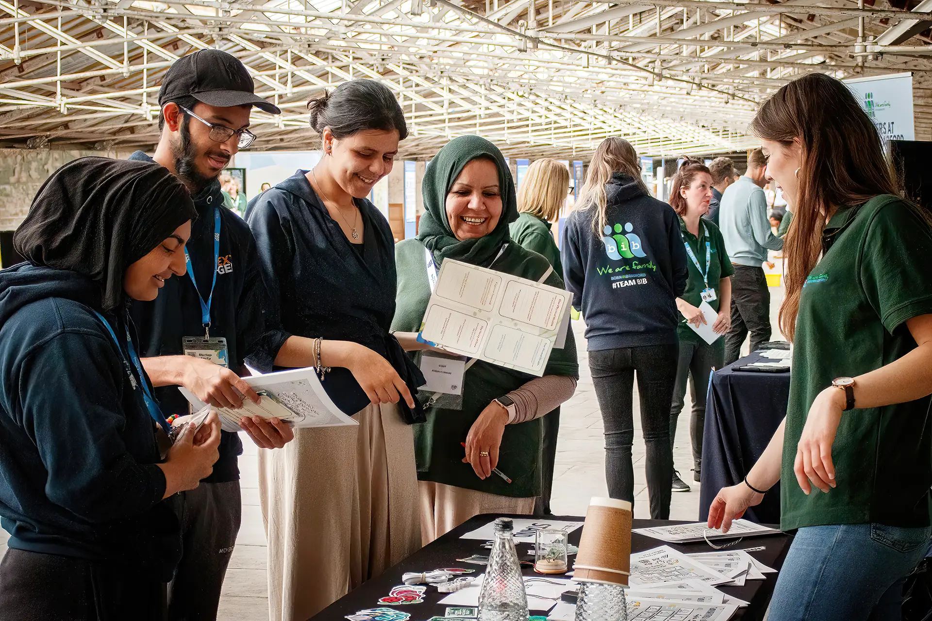 Volunteers with members of the public looking through resources at fair