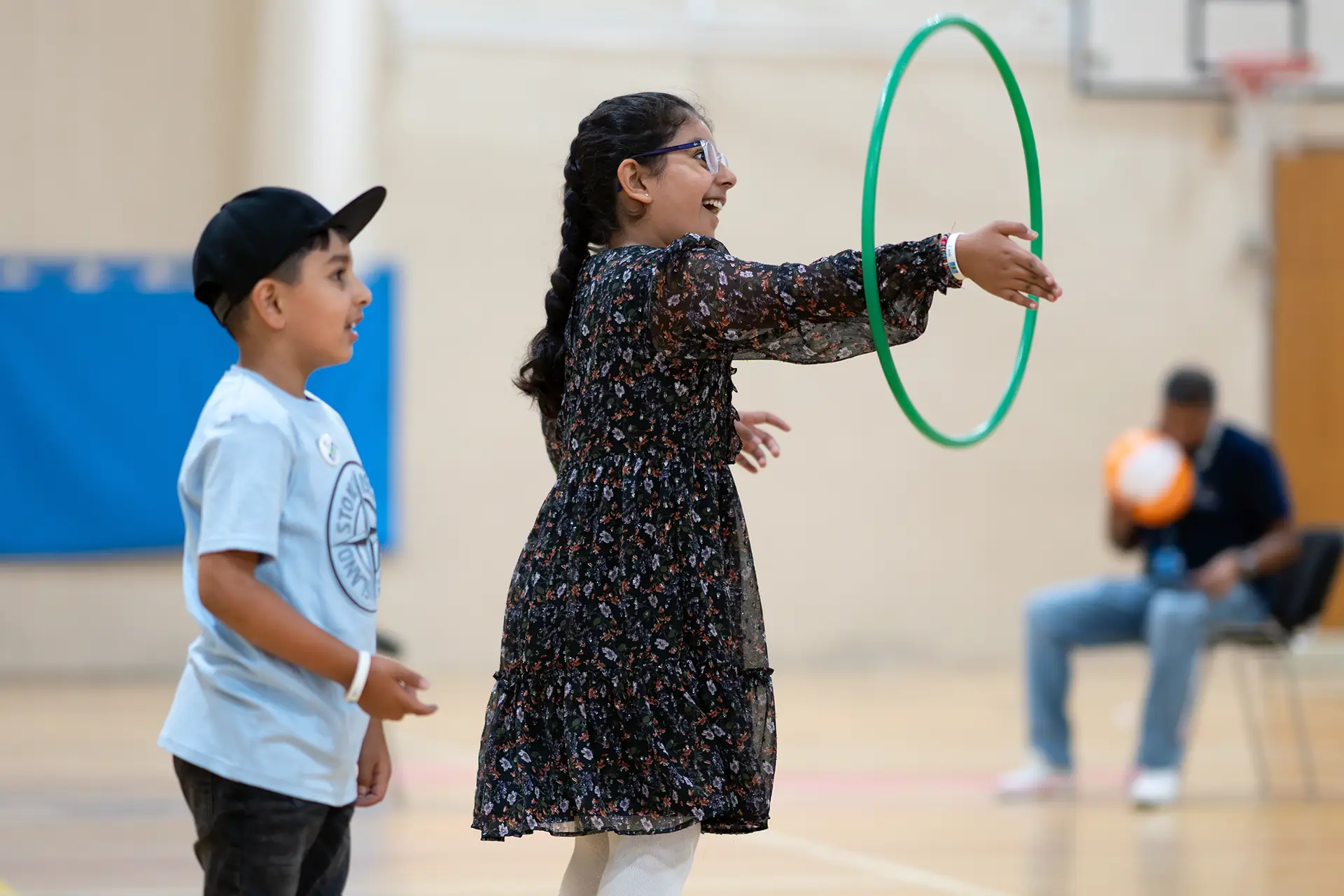 Children playing in sports hall with hoolahoops