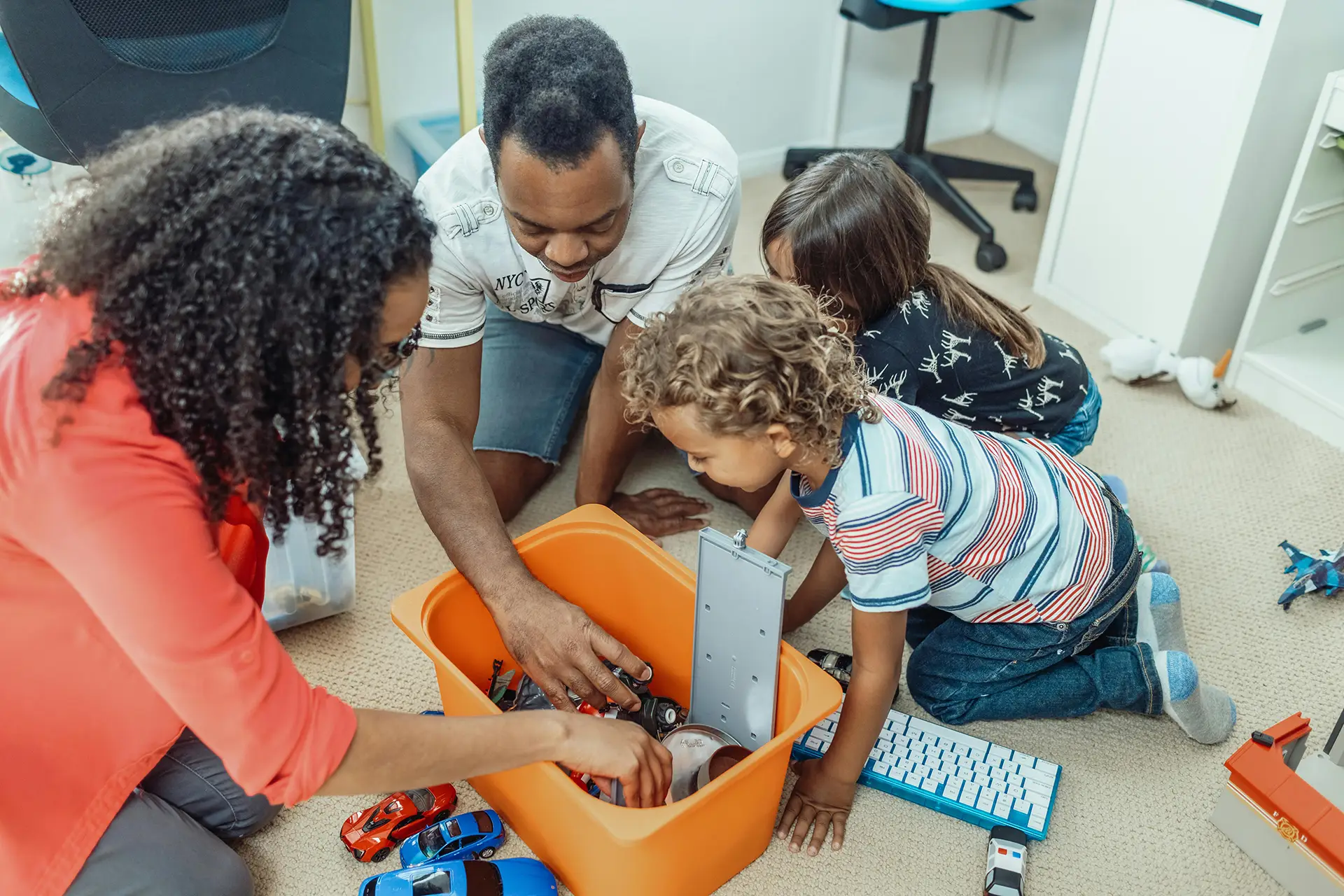 Parents with two children, rooting through toy box