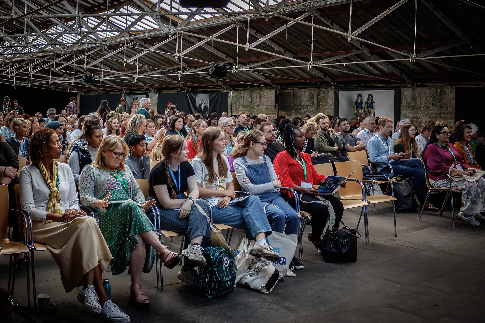 Audience members sat watching a stage in a big hall