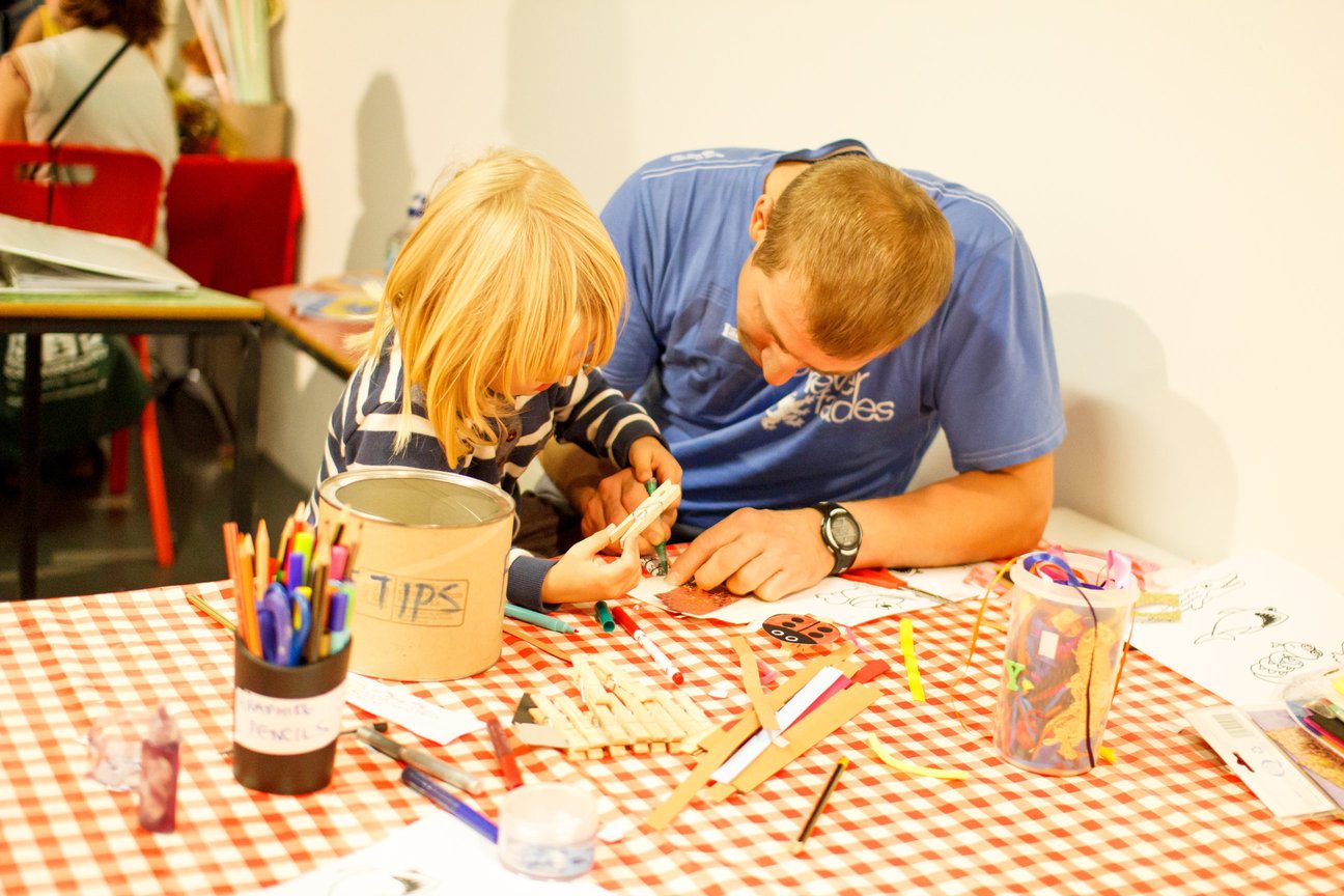 Child with father drawing at a kitchen table